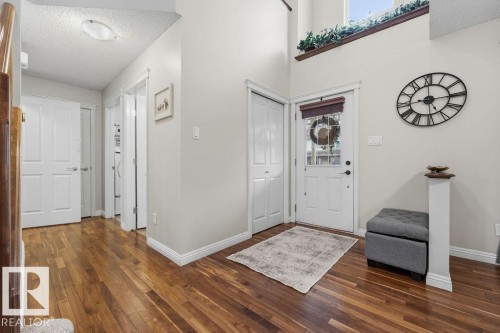 Spacious entry featuring wood-finish flooring, a white paneled front door with decorative glass, and a high ceiling - 1613 Kerr Road, Edmonton, AB - Indoor Photo Showing Other Room