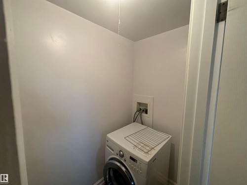 Dedicated laundry area featuring white walls and a visible utility hookup - 111 10225 117 Street, Edmonton, AB 