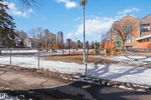 This property is located near a community park featuring playground equipment, open grounds, and established trees - 111 10225 117 Street, Edmonton, AB 