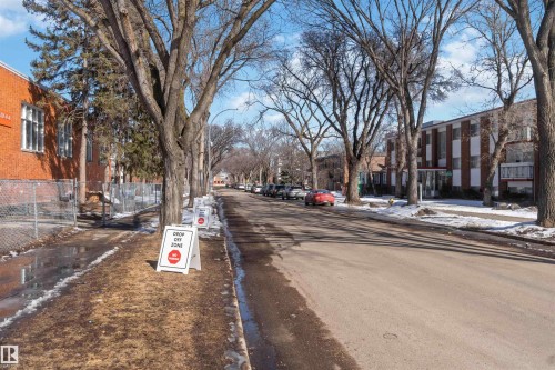 The neighborhood features mature trees lining the street, creating a pleasant streetscape - 111 10225 117 Street, Edmonton, AB 