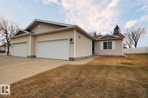 Siding exterior with a double attached garage and concrete driveway - 8146 27 Avenue, Edmonton, AB - Outdoor