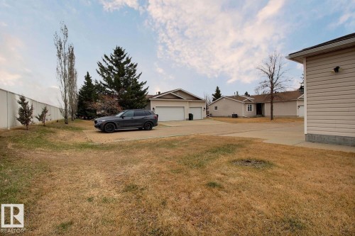 Spacious lot featuring a concrete driveway, established trees, and a beige exterior with white trim - 8146 27 Avenue, Edmonton, AB - Outdoor