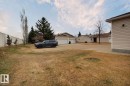 Spacious lot featuring a concrete driveway, established trees, and a beige exterior with white trim - 8146 27 Avenue, Edmonton, AB  - Outdoor 