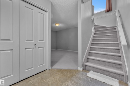 Tiled entry flooring with bi-fold closet doors - 110 13825 155, Edmonton, AB - Indoor Photo Showing Other Room