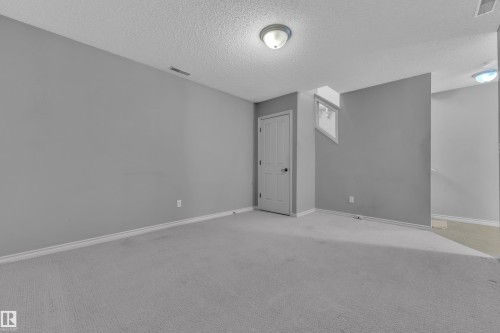 Carpeted room with light grey walls, white trim, and a textured ceiling - 110 13825 155, Edmonton, AB - Indoor Photo Showing Other Room