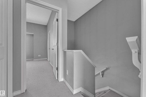 Interior hallway featuring light gray wall paint, white trim, and carpeted flooring - 110 13825 155, Edmonton, AB - Indoor