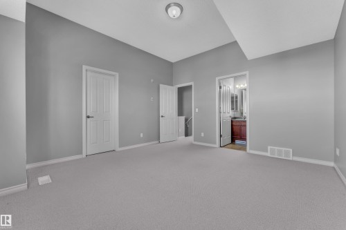 Spacious carpeted room featuring light gray walls and white trim - 110 13825 155, Edmonton, AB - Indoor Photo Showing Other Room