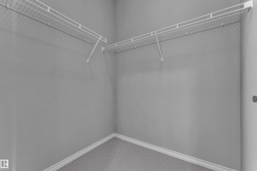 Corner closet with wire shelving system and light gray carpet - 110 13825 155, Edmonton, AB - Indoor With Storage