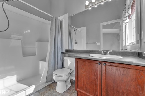 Full bathroom featuring a white shower/tub combination, a toilet, and a vanity with a surface-mounted sink - 110 13825 155, Edmonton, AB - Indoor Photo Showing Bathroom