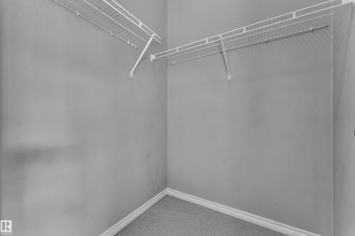Walk-in closet with wire shelving system and light grey wall finishes - 110 13825 155, Edmonton, AB - Indoor With Storage