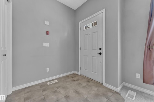 Entryway featuring a paneled door with decorative glass inserts and matte black hardware - 110 13825 155, Edmonton, AB - Indoor Photo Showing Other Room