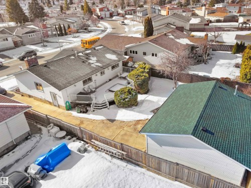 White-sided residence featuring a multi-level deck and stone chimney - 11044 166 Avenue, Edmonton, AB - Outdoor With In Ground Pool