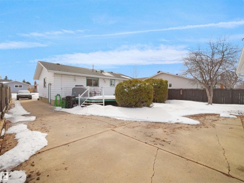 Rear exterior featuring a white siding finish, a wood deck with white railings, and a fenced backyard - 11044 166 Avenue, Edmonton, AB - Outdoor