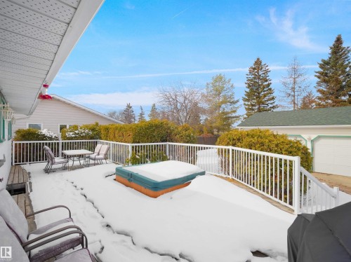 Expansive outdoor deck featuring white railing, integrated hot tub, and exterior lighting - 11044 166 Avenue, Edmonton, AB - Outdoor With Deck Patio Veranda With Exterior