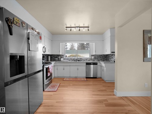 Kitchen featuring light wood-finish flooring, white cabinetry, and stainless steel appliances - 11044 166 Avenue, Edmonton, AB - Indoor Photo Showing Kitchen With Stainless Steel Kitchen