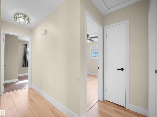 Hallway featuring wood-finish flooring, light neutral wall paint, and white trim - 11044 166 Avenue, Edmonton, AB - Indoor Photo Showing Other Room