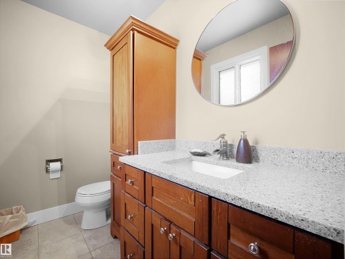 Bathroom vanity featuring a light-toned speckled countertop, an integrated rectangular sink, and a chrome faucet - 11044 166 Avenue, Edmonton, AB - Indoor Photo Showing Bathroom