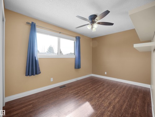 Spacious room featuring wood-finish flooring, a ceiling fan with integrated lighting, and a window for natural illumination - 11044 166 Avenue, Edmonton, AB - Indoor Photo Showing Other Room
