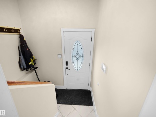 Entryway featuring a white door with decorative glass inserts, square tile flooring, and light-toned walls - 11044 166 Avenue, Edmonton, AB - Indoor