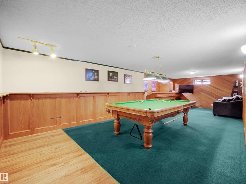 Recreation room featuring a paneled wood accent wall, wood-finish flooring, recessed lighting, and a suspended light fixture - 11044 166 Avenue, Edmonton, AB - Indoor Photo Showing Other Room