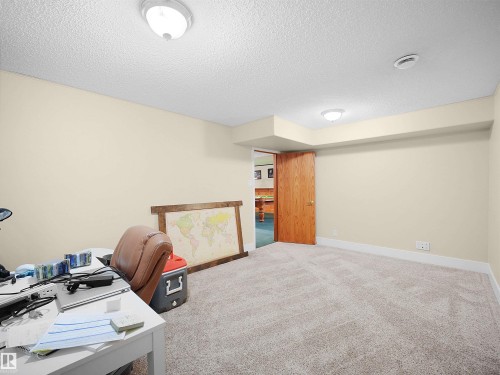 Carpeted room with neutral-toned walls, white trim, and a wood-finish door - 11044 166 Avenue, Edmonton, AB - Indoor Photo Showing Office