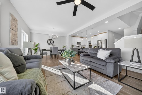 Open concept living area featuring wood-finish flooring, a modern black ceiling fan, and recessed lighting - 20723 24 Avenue, Edmonton, AB - Indoor Photo Showing Living Room
