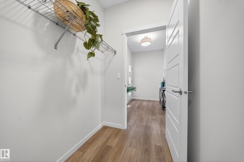 Interior hallway featuring wood-finish flooring, light neutral wall tones, and white trim - 20723 24 Avenue, Edmonton, AB - Indoor Photo Showing Other Room