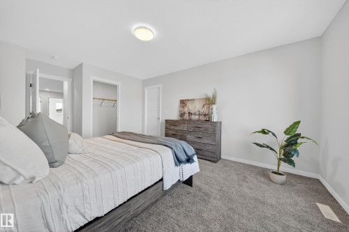 Carpeted bedroom featuring light gray walls, a flush-mount ceiling light, and white trim - 20723 24 Avenue, Edmonton, AB - Indoor Photo Showing Bedroom