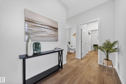 Open hallway with wood-finish flooring, crisp white walls, and bright overhead lighting - 20723 24 Avenue, Edmonton, AB - Indoor Photo Showing Other Room