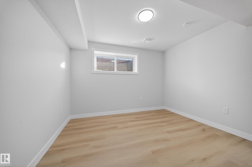 Bright interior room featuring wood-finish flooring, white walls, and recessed lighting - 20723 24 Avenue, Edmonton, AB - Indoor Photo Showing Other Room