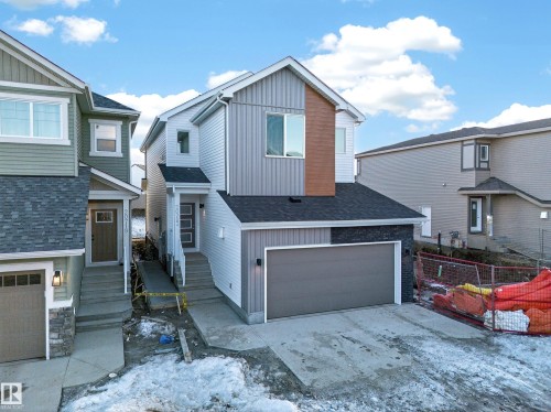 Contemporary two-story exterior featuring multi-textured siding, an integrated single-car garage, front entry porch, and dark shingle roofing - 20723 24 Avenue, Edmonton, AB - Outdoor