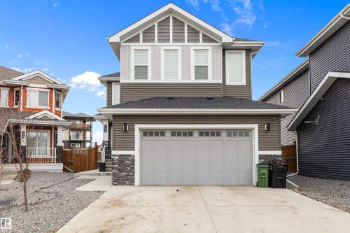 Modern two-story residence featuring a two-car garage, stone facade accents, horizontal siding, and a gabled roofline - 714 Ebbers Place, Edmonton, AB - Outdoor