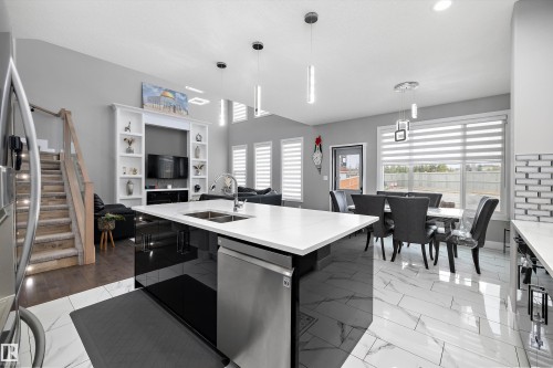 Gourmet kitchen island with an undermount double sink, stainless steel dishwasher, and a white countertop - 714 Ebbers Place, Edmonton, AB - Indoor