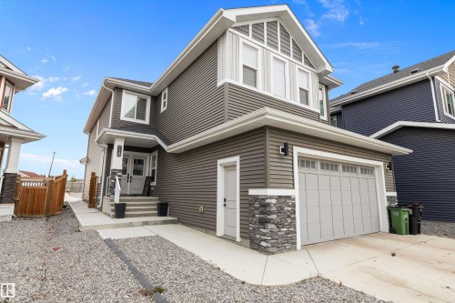 Two-story residence featuring gray horizontal siding and decorative stone accents - 714 Ebbers Place, Edmonton, AB - Outdoor