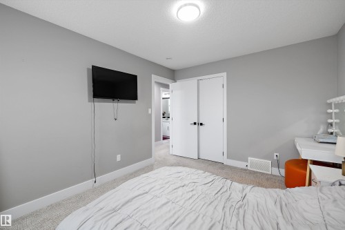 Carpeted room featuring light gray walls, white baseboards, and a flush-mount ceiling light - 714 Ebbers Place, Edmonton, AB - Indoor Photo Showing Bedroom