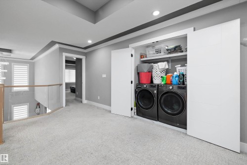 Integrated laundry closet featuring front-loading washer and dryer units - 714 Ebbers Place, Edmonton, AB - Indoor Photo Showing Laundry Room