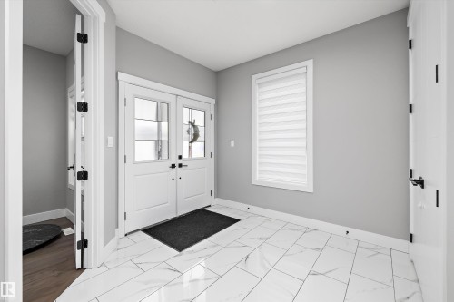 Entryway featuring white marble-look tile flooring and light gray walls - 714 Ebbers Place, Edmonton, AB - Indoor Photo Showing Other Room