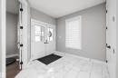 Entryway featuring white marble-look tile flooring and light gray walls - 714 Ebbers Place, Edmonton, AB  - Indoor Photo Showing Other Room 