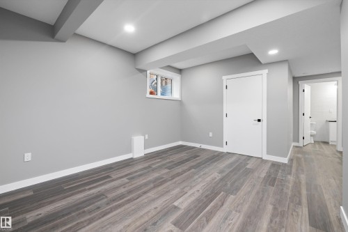 Spacious room featuring wood-finish flooring, recessed lighting, and a white trim package - 714 Ebbers Place, Edmonton, AB - Indoor Photo Showing Other Room