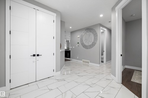 Spacious entryway with large format white tile flooring and recessed lighting - 714 Ebbers Place, Edmonton, AB - Indoor Photo Showing Other Room