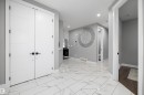 Spacious entryway with large format white tile flooring and recessed lighting - 714 Ebbers Place, Edmonton, AB  - Indoor Photo Showing Other Room 
