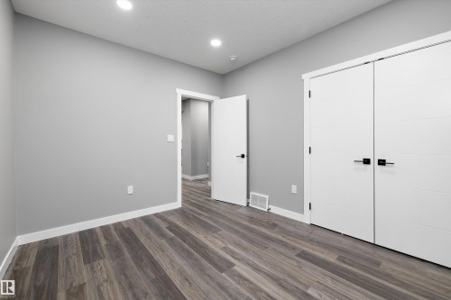 Interior room featuring wood-finish flooring, light gray walls, and white trim - 714 Ebbers Place, Edmonton, AB - Indoor Photo Showing Other Room