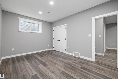 Spacious room featuring wood-finish flooring, recessed lighting, and a window with blinds - 714 Ebbers Place, Edmonton, AB - Indoor Photo Showing Other Room