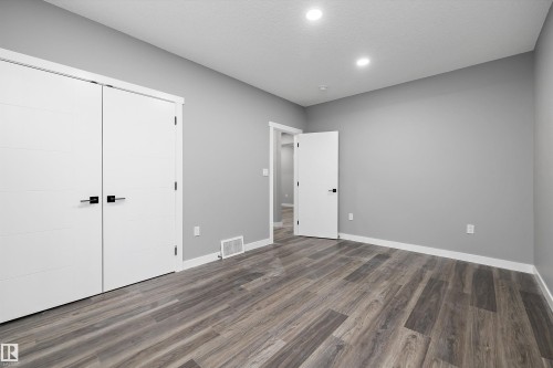 Neutral gray walls with white trim and wood-finish flooring - 714 Ebbers Place, Edmonton, AB - Indoor Photo Showing Other Room