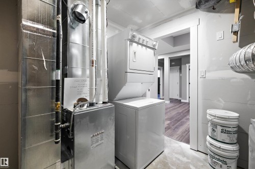 Utility room featuring a furnace, water heater, and a stacked washer and dryer - 714 Ebbers Place, Edmonton, AB - Indoor Photo Showing Laundry Room