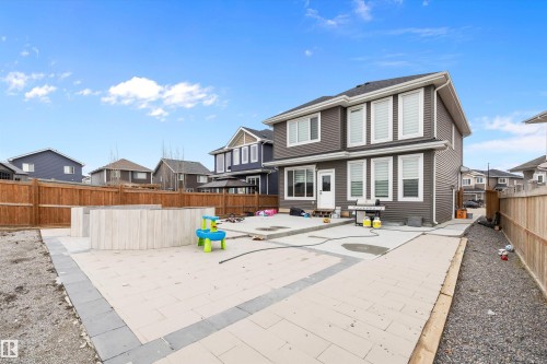 Spacious backyard featuring a large paver patio, a built-in wood-paneled garden bed, and a gravel side yard - 714 Ebbers Place, Edmonton, AB - Outdoor