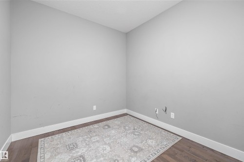 Room featuring neutral-toned walls, wood-finish flooring, and white baseboards - 714 Ebbers Place, Edmonton, AB - Indoor Photo Showing Other Room