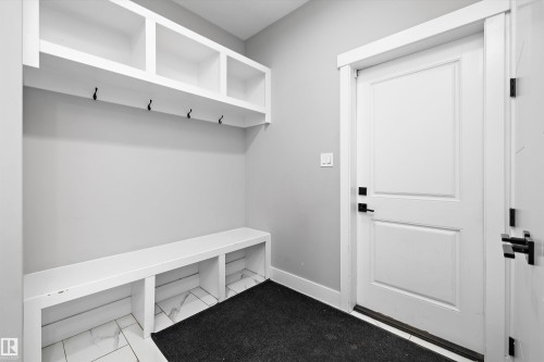 Built-in mudroom bench with cubbies, overhead shelving, and multiple coat hooks - 714 Ebbers Place, Edmonton, AB - Indoor