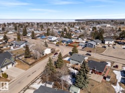 Aerial perspective of a residential neighborhood with a large body of water in the background - 