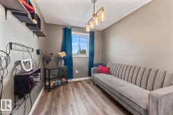 Room featuring wood-finish flooring, a window with blue drapes, and a contemporary ceiling light fixture - 